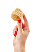 Hand with red nails holding single Floppy Ear natural dried beef trachea chew showing textured ring structure