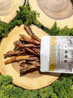 Floppy Ear 100% Natural Scottish Wild Venison Strips Air Dried Dog Treat pouch on wooden slice with moss