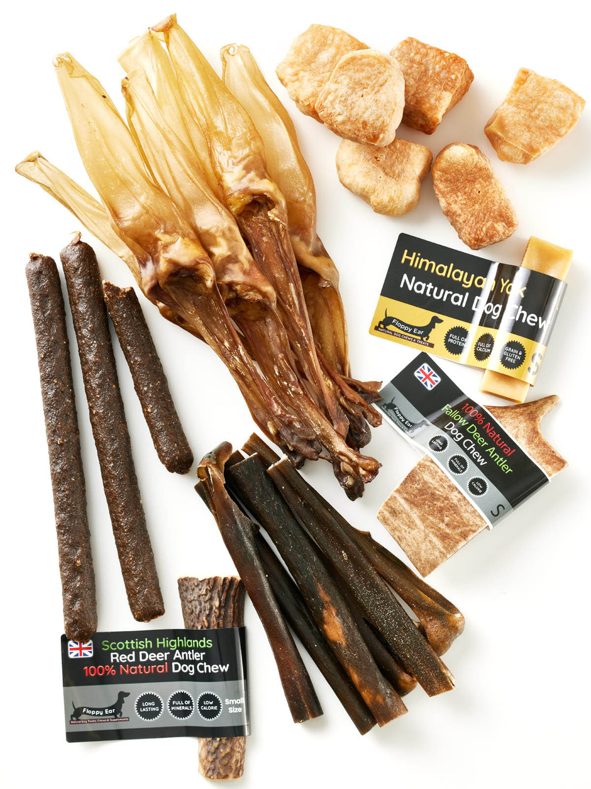 Flat lay of all contents from Floppy Ear Small Puppy Box – Himalayan yak chews, Scottish Highlands red deer antler, fallow deer antler and natural beef strips on white background