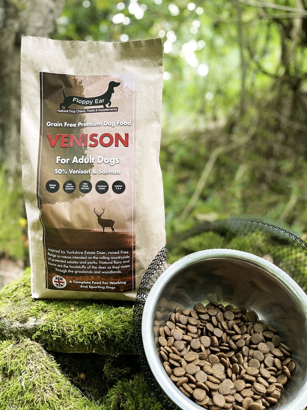 Floppy Ear Grain Free Premium Dog Food 50% Venison & Salmon full pouch with kibble bowl on moss