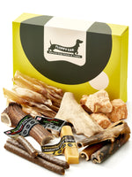 Floppy Ear Large Puppy Box closed with selection of natural dog chews and treats arranged in the foreground