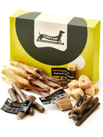 Floppy Ear Small Puppy Box closed with selection of natural dog chews and treats arranged in the foreground